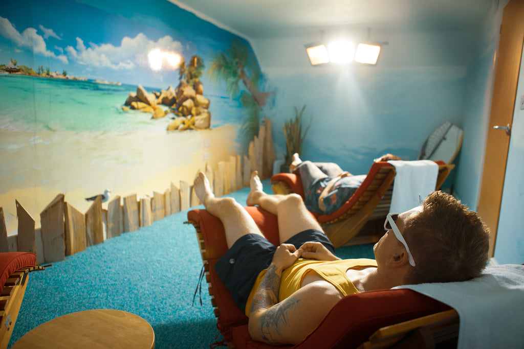 Guest relaxing under warm light in the Seychelles Sunroom at Shropshire Floatation and Wellness Centre — vitamin D light therapy, Myddle Shrewsbury.